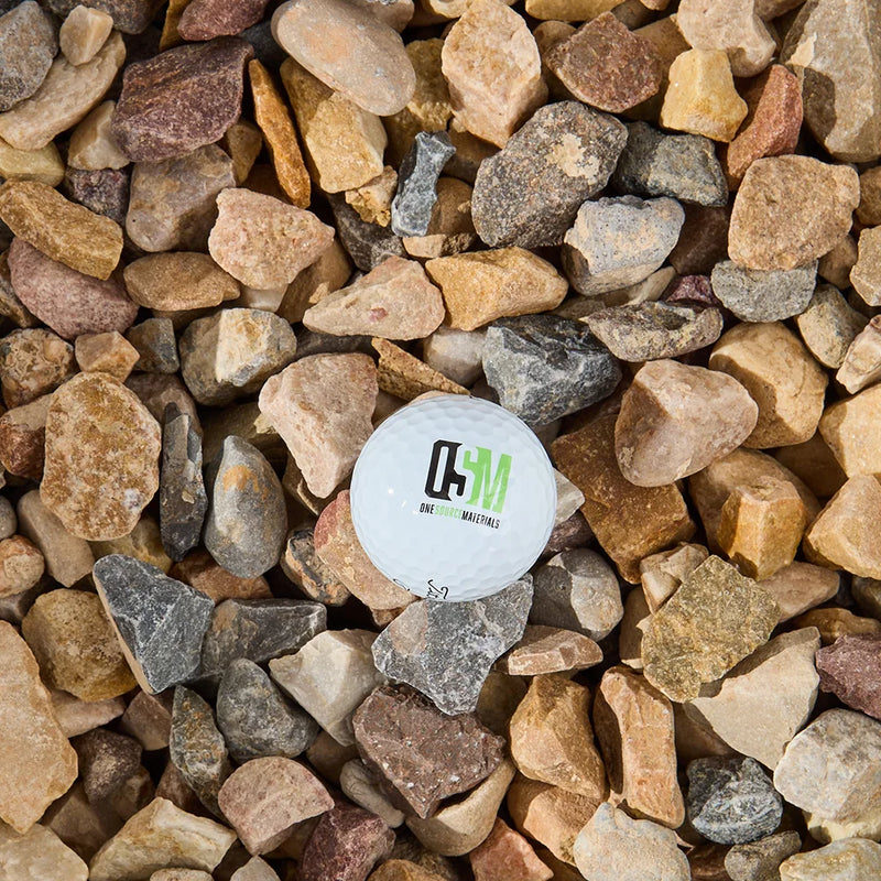 Close-up of multicolored stones with a branded white golf ball in the center.