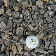 Small stones with a golf ball displaying a logo on a bed of stones