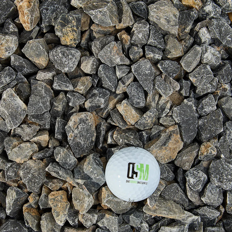 Small stones with a golf ball displaying a logo on a bed of stones