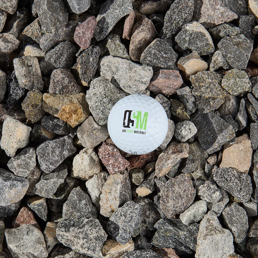 White ball with the One Source Materials logo on a bed of small stones