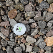 White golf ball with a logo on a bed of small stones