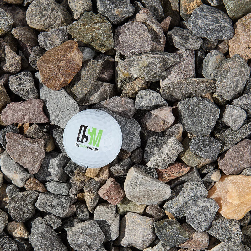 White golf ball with a logo on a bed of small stones