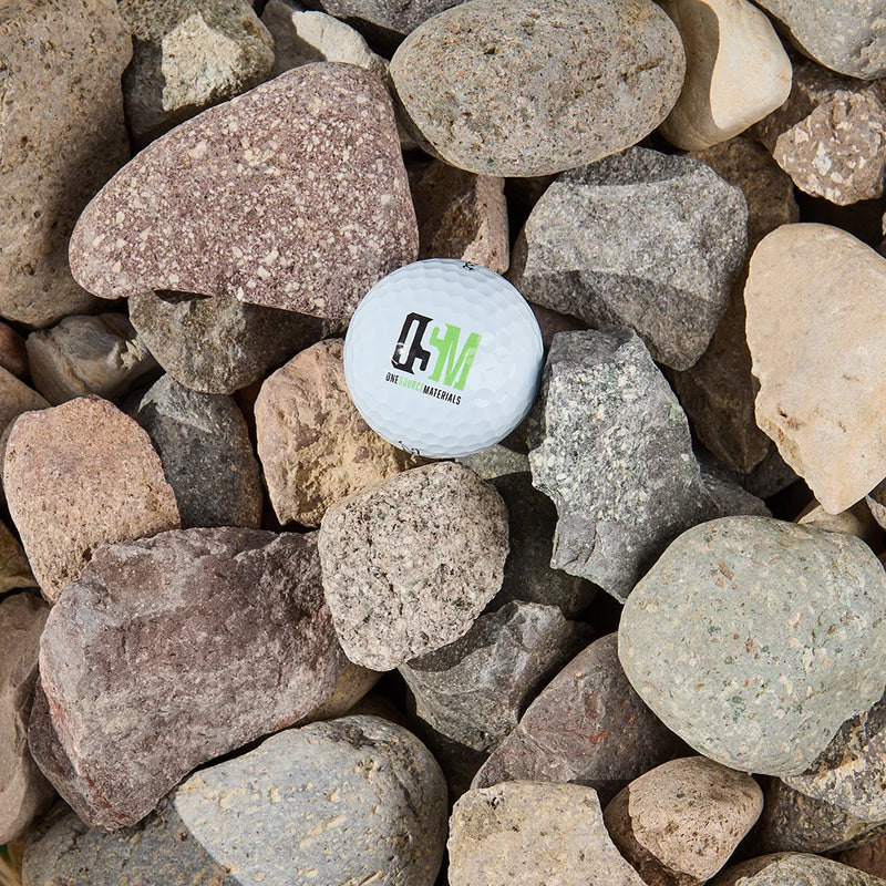 White golf ball with the OSM logo on a bed of stones