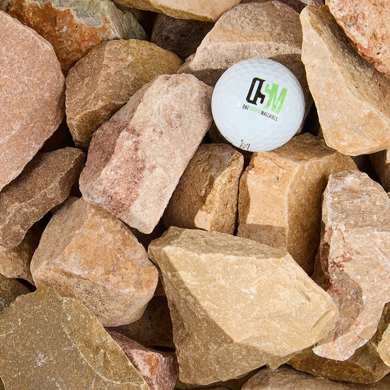 White ball with a logo embedded in a pile of stones