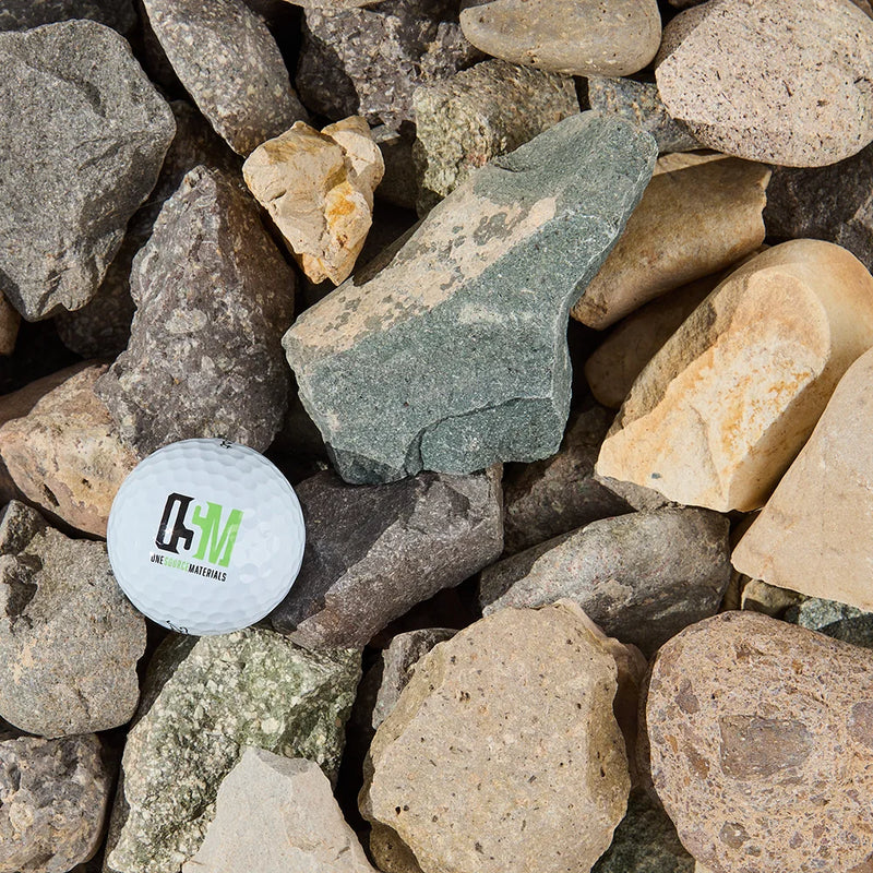 White ball with a logo on a bed of rocks