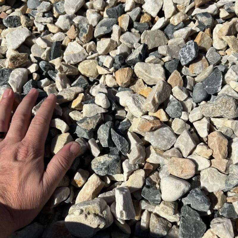 Hand reaching into a pile of small stones and pebbles