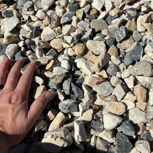Hand reaching into a pile of small stones and pebbles