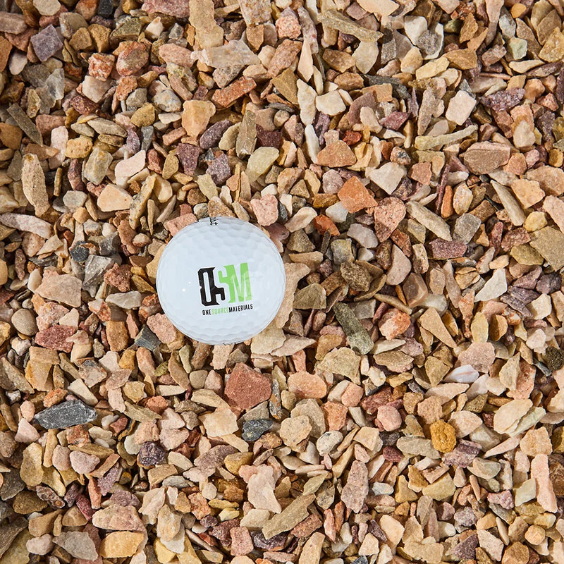 Small white ball with a logo on a bed of multicolored gravel