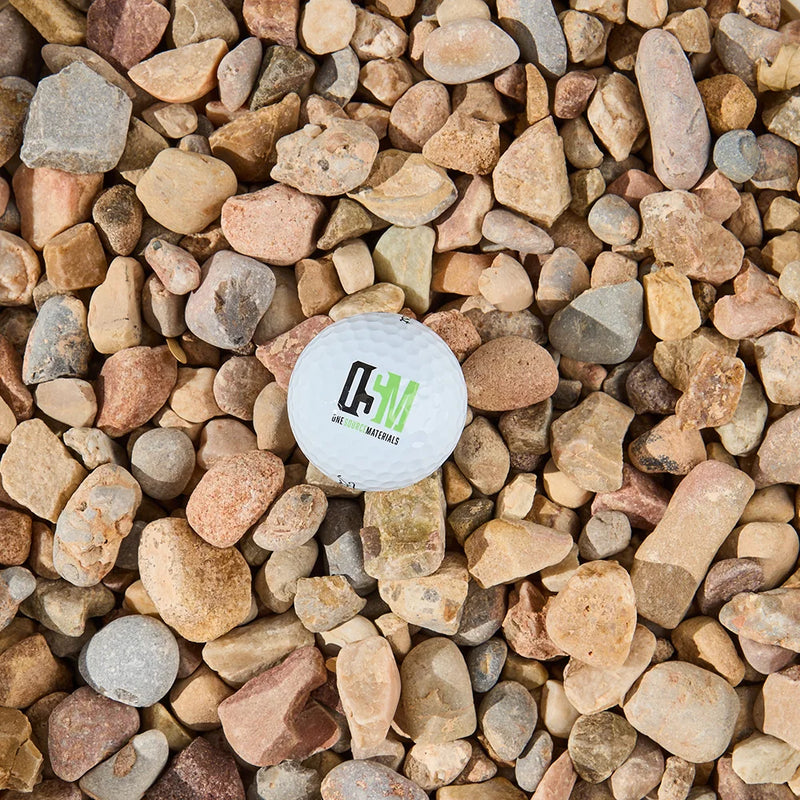 Golf ball with a logo on a bed of multicolored stones
