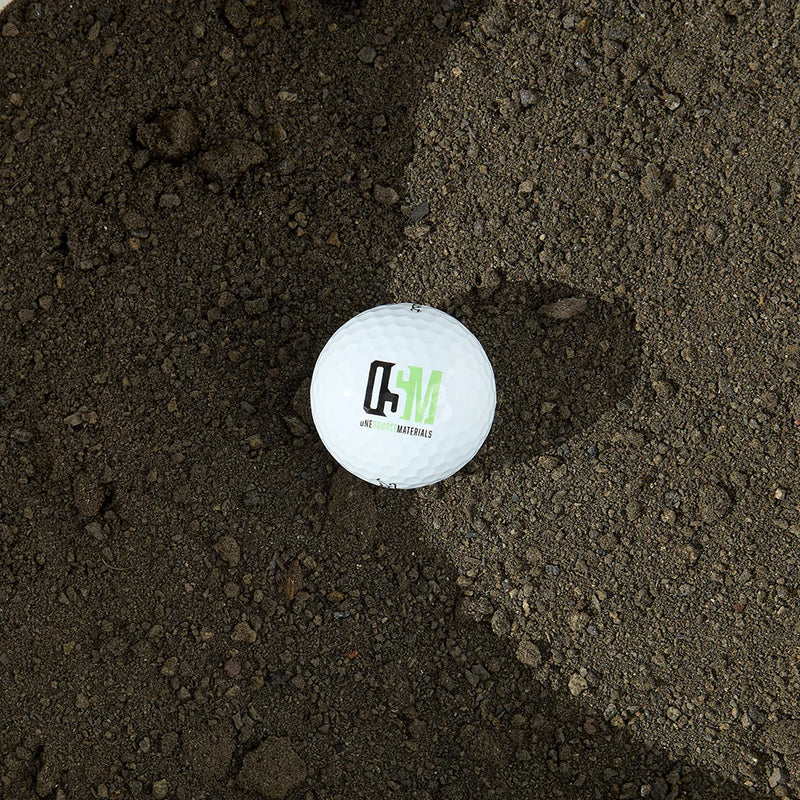 Golf ball with the OSM logo on black lava fines