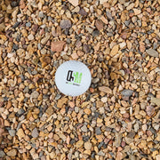 Small white ball with a logo on a bed of multicolored stones