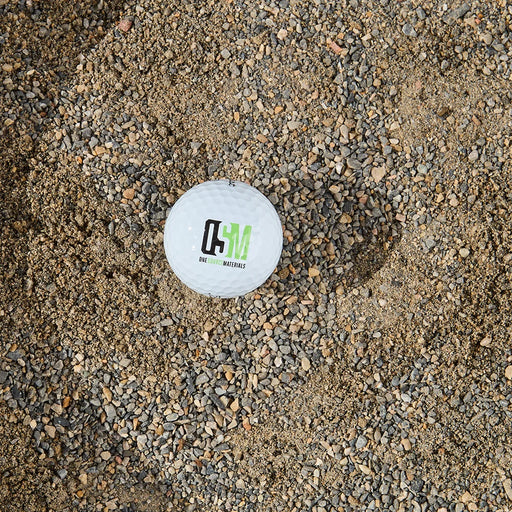 Golf ball with a logo on a gravel surface