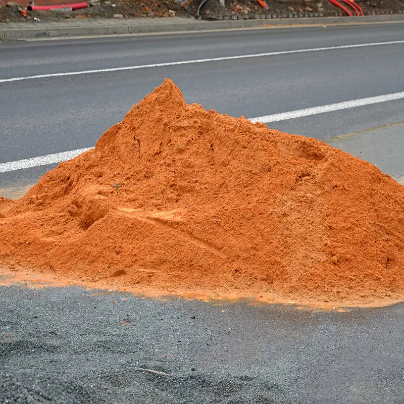 on the street lies a folded pile of sand or red clay.
