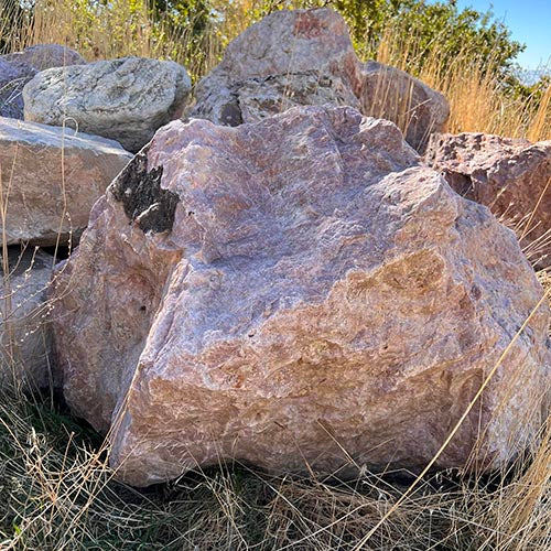 Hot springs boulders in a natural setting with grass and trees